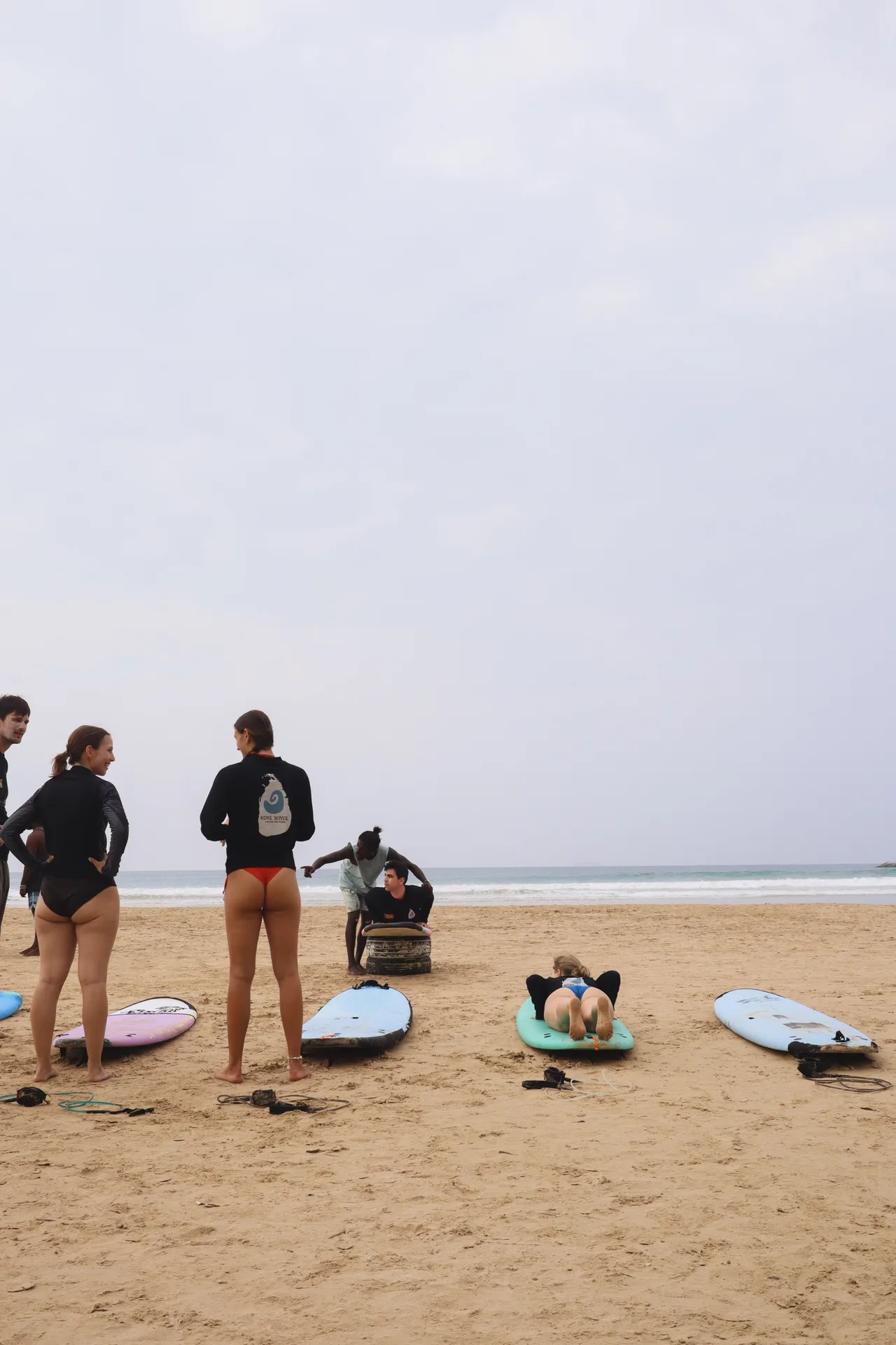 Surfers learning together on the sand at Kabalana